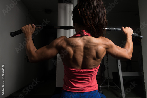 Fitness Woman Doing Exercise For Back On Machine