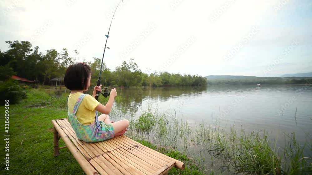 Happy girl pulling rod while fishing against landscape of lake. Happy girl pulling rod while fishing against landscape of lake.
