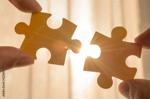 Hand holding piece of blank jigsaw puzzle. idea, sign, symbol, of connecting completing the final puzzle piece. team support and help concept