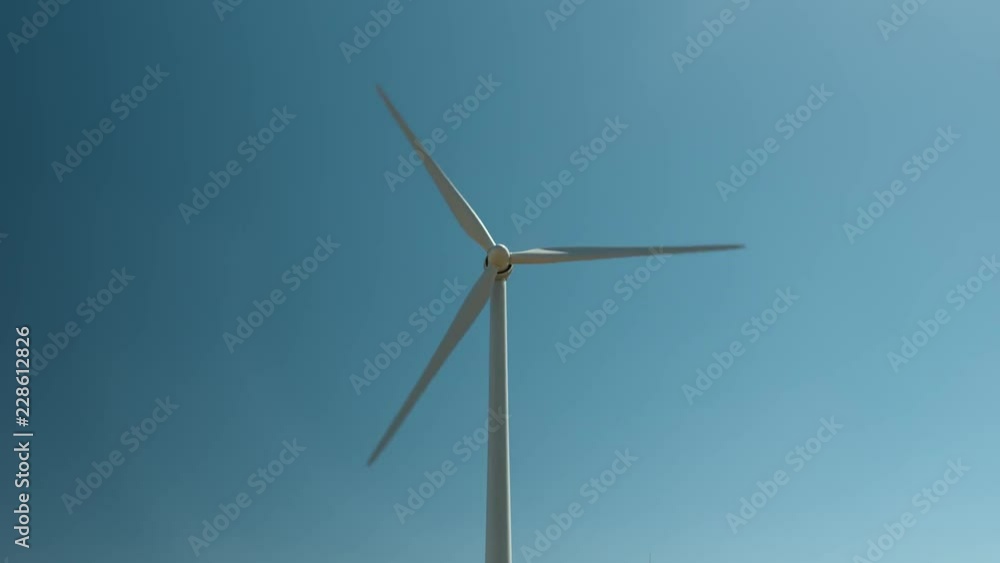 Central shot looking directly at wind tower rotating against a blue sky - HD. Central shot looking directly at wind tower rotating against a blue sky - HD.