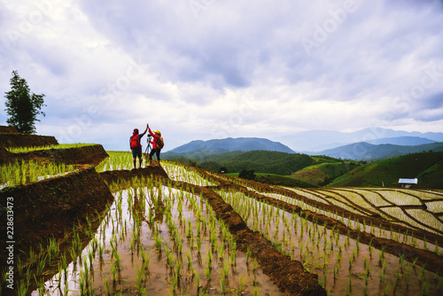 Wallpaper Mural Travel nature lover asian woman and asian man walking take a photo on the field in rainy season. Torontodigital.ca