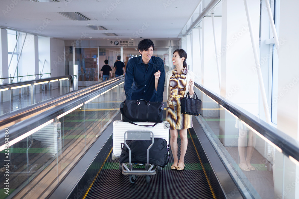 腕組みをしながら空港を移動するカップル Stock 写真 Adobe Stock