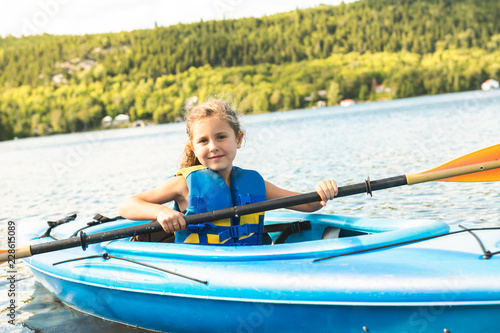 Summer vacation Portrait of happy cute girl kayaking the on river