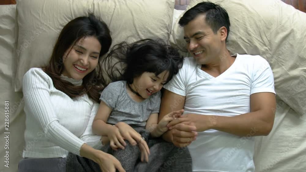 lovely moment family concept with daughter and parent playing together in blanket on soft bed morning time lovely moment family concept with daughter and parent playing together in blanket on soft bed morning time