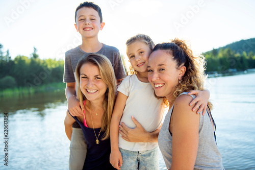woman and mother have fun with childs close to a lake