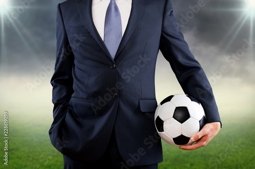 Business man hand holding football ball