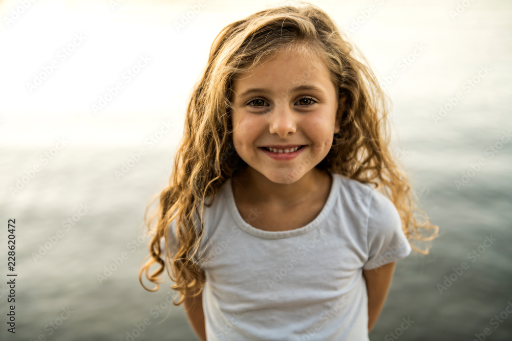 Cute child girl on a wooden platform by the lake. Cute child girl on a wooden platform by the lake.