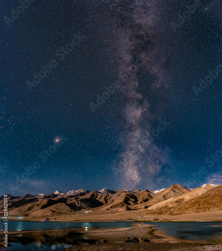 Panorama of arching Milky Way galactic center over the mountain at Pangong Lake or Pangong Tso, Ladakh, Jammu and Kashmir, India. photo