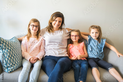 mother and daughters on sofa at home
