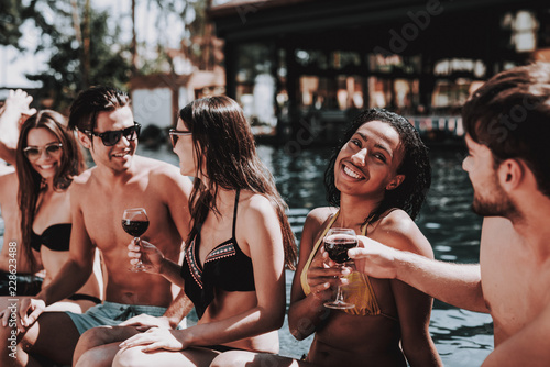 Young Smiling Friends Drinking Wine at Poolside © VadimGuzhva