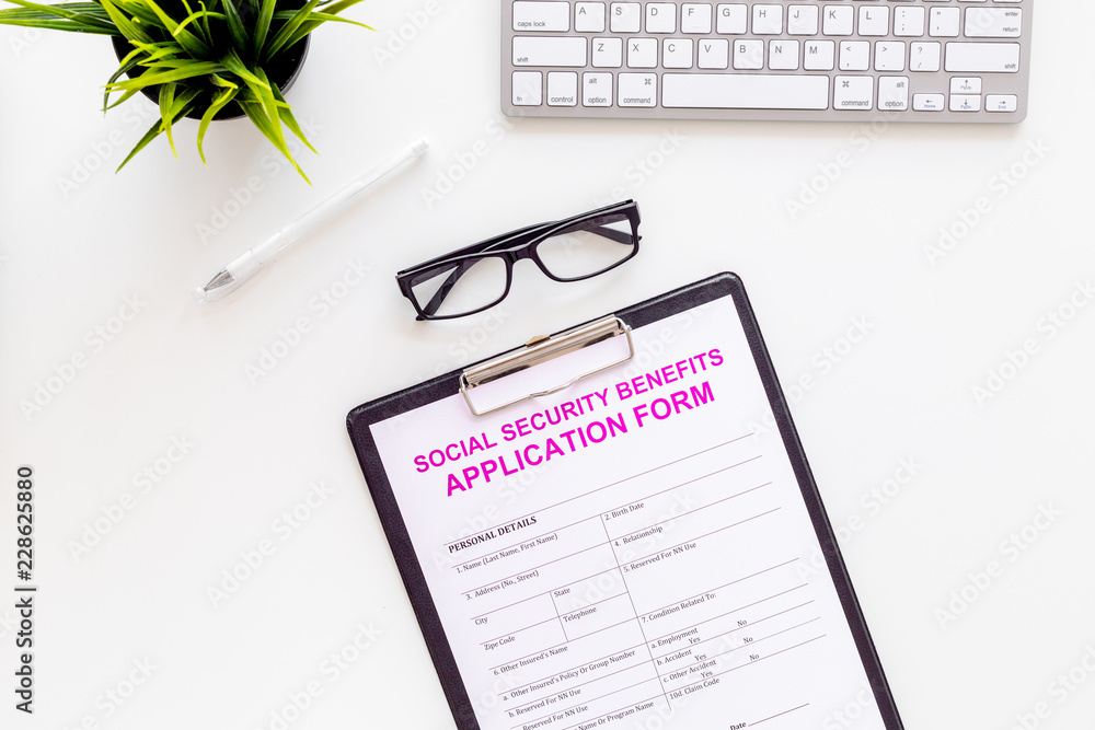 Social security benefits. Application form near pen and glasses on white background top view Social security benefits. Application form near pen and glasses on white background top view