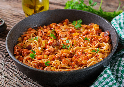 Spaghetti bolognese pasta with tomato sauce, vegetables and minced meat - homemade healthy italian pasta on rustic wooden background.
