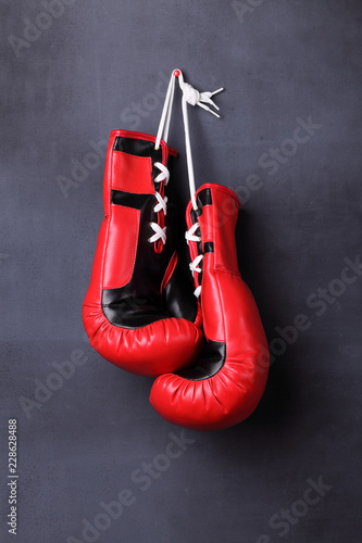 Boxing gloves hanging on a black wall © jivimages