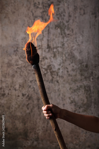 Human hand holding a flaaming torch
