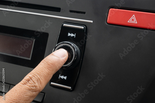 hand pressing opening audio button on car. button on and off.