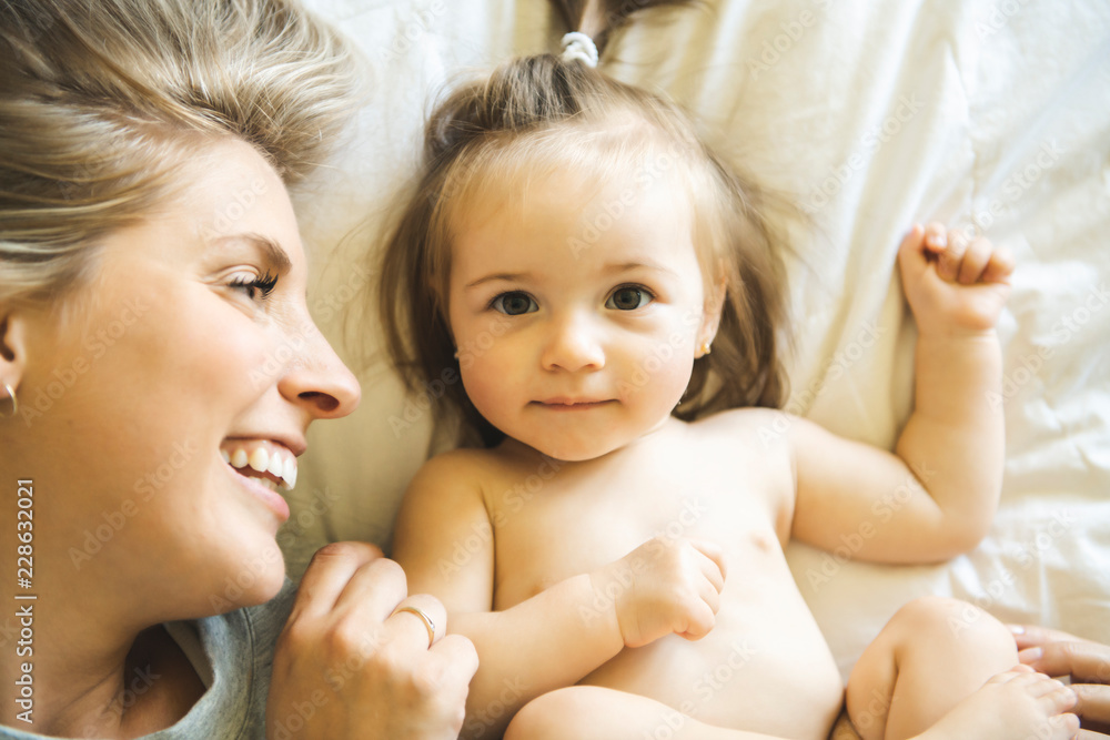 Mother and his baby daughter on bed having fun Mother and his baby daughter on bed having fun