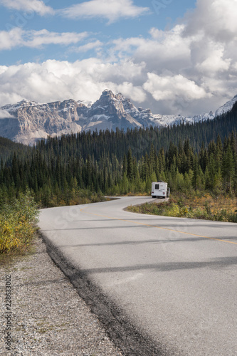 RV Motorhome Camper on Road in the Canadian Rockies with serene scenery