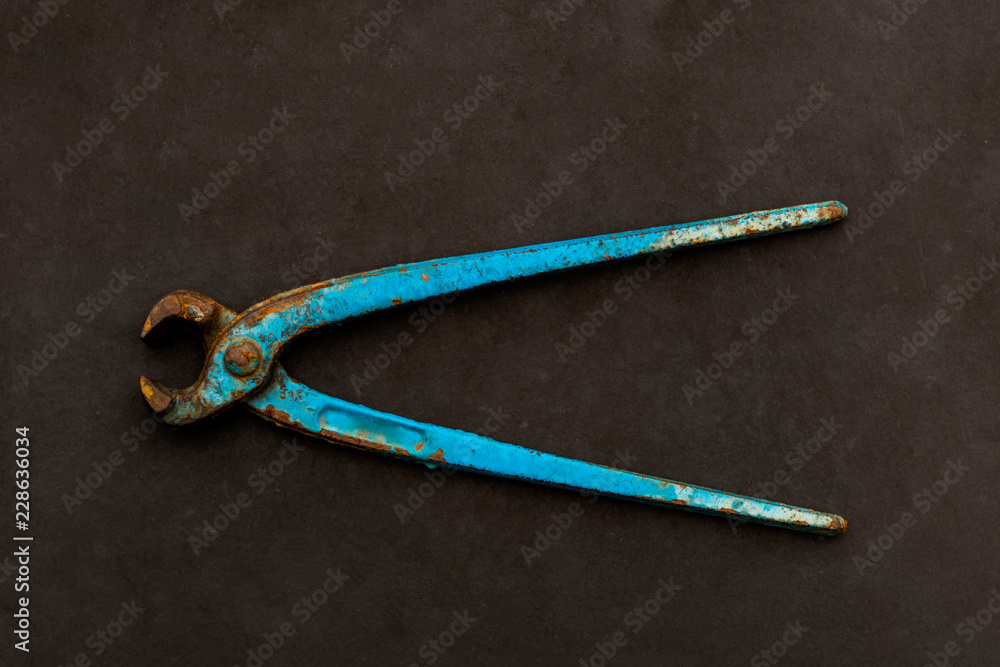 Metal wire cutter, old gripper on a dark gray background. Metal wire cutter, old gripper on a dark gray background.