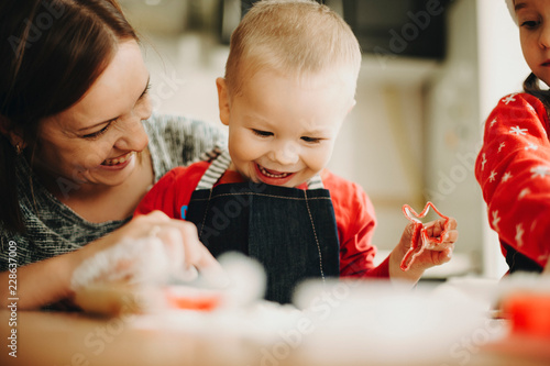 Charming infant boy with mother making cookies