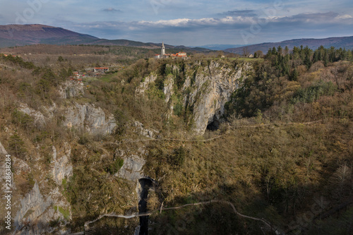 Unesco world heritage site Skocjanske jame with village Skocjan and collapse doline with cave entrances and paths, Slovenia photo