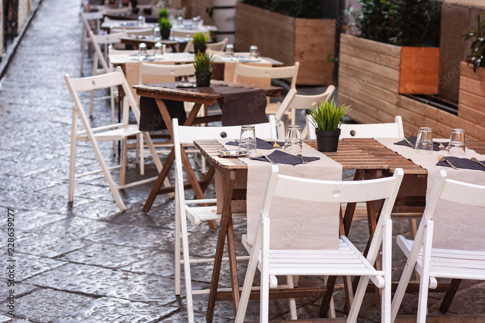 Tables with chairs on the terrace in a café in Catania, Sicily, Italy