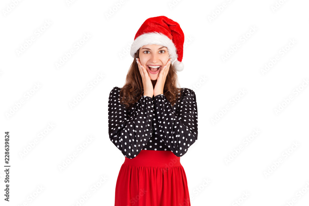 woman in dress being uplifted and touched holding hands on face open eyes and smiling broadly. emotional girl in santa claus christmas hat isolated on white background. holiday concept woman in dress being uplifted and touched holding hands on face open eyes and smiling broadly. emotional girl in santa claus christmas hat isolated on white background. holiday concept