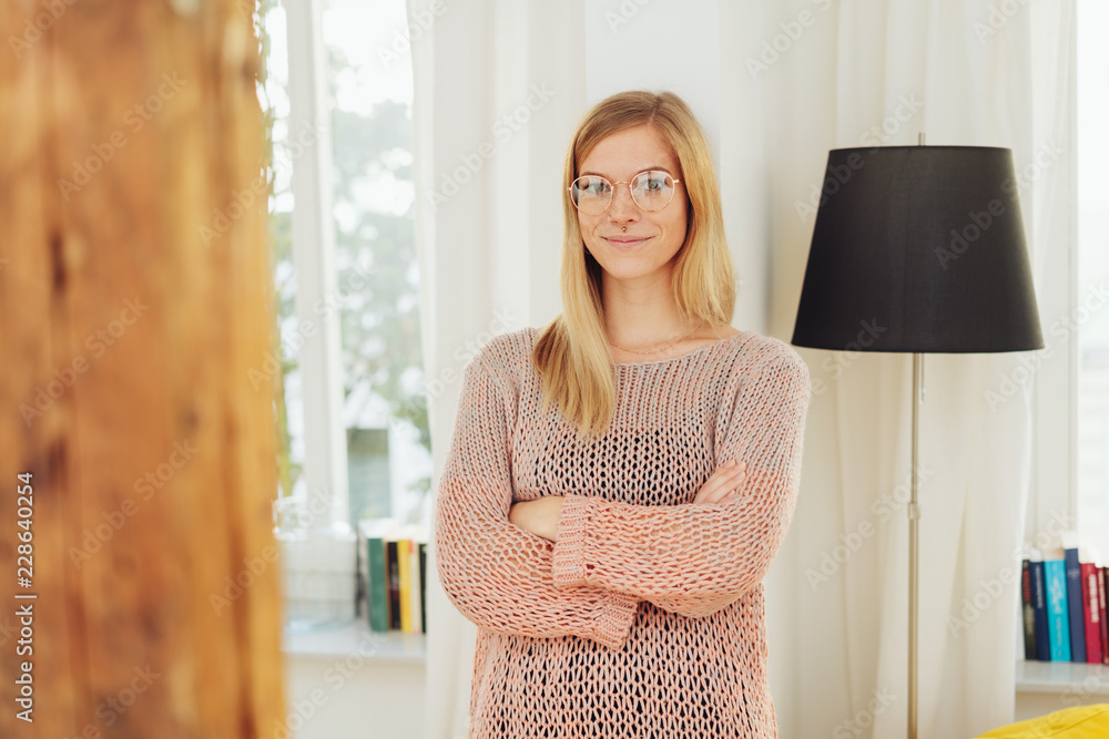 Smiling woman with crossed arms standing near lamp Smiling woman with crossed arms standing near lamp