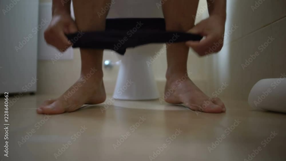 Man sick with diarrhea sitting in toilet, suffering from indigestion, health Man sick with diarrhea sitting in toilet, suffering from indigestion, health