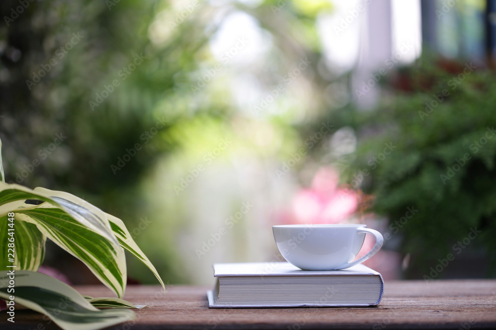 White cup with plant and notebooks White cup with plant and notebooks