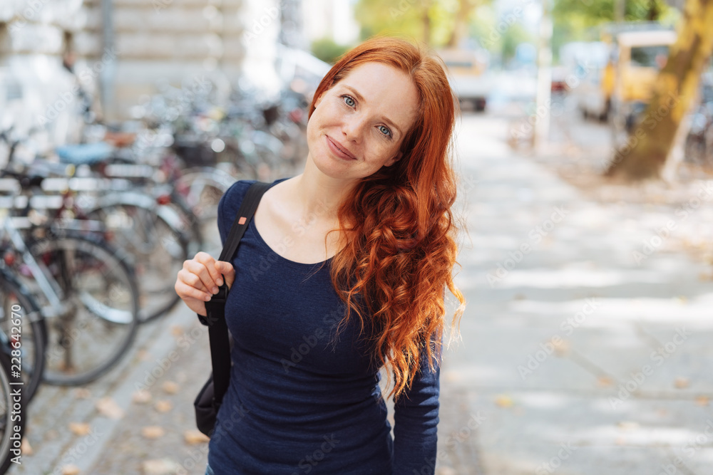 Friendly young redhead woman wearing a backpack Friendly young redhead woman wearing a backpack