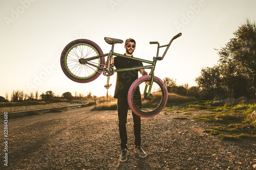 Bmx bike rider in a sunset. Guy riding a bmx bike
