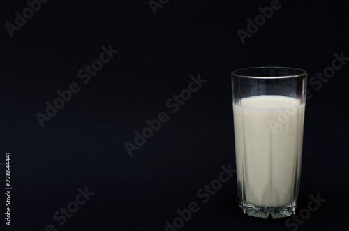 Glass of milk on the black background