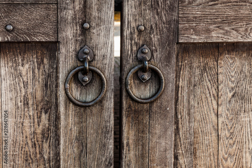 Fotografie Fragment of an ancient wooden gate with iron rings
