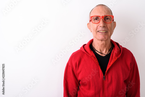 Studio shot of happy bald senior man smiling while wearing eyegl © Ranta Images