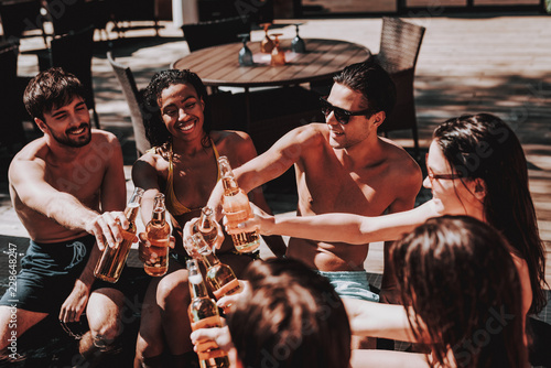 Young Friends with Alcoholic Drinks at Poolside