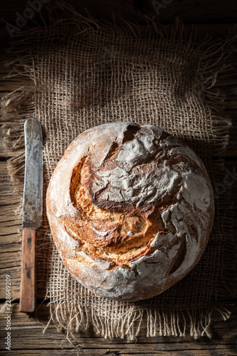 Fényképezés Tasty loaf of bread on dark and rustic table