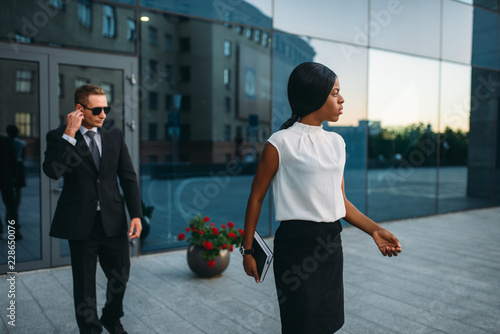 Business woman, bodyguard in suit on background photo