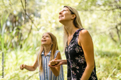 Portrait of a happy young girl outdoors forest with babysitter photo