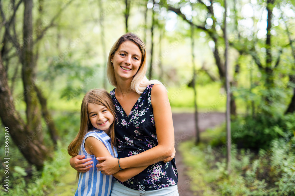 Portrait of a happy young girl outdoors forest with babysitter Portrait of a happy young girl outdoors forest with babysitter