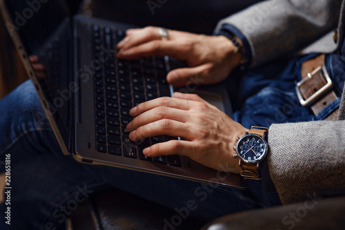 Stylish guy working on a laptop. Laptop on lap