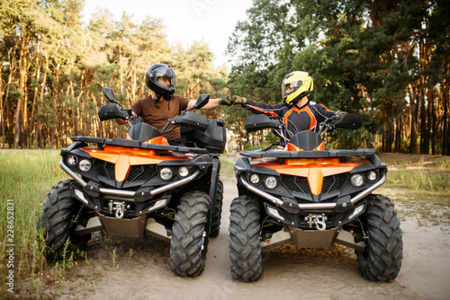 Two atv riders hits fists for good luck, back view