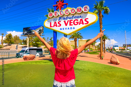 Photography Carefree woman with raised arms at Welcome to Fabulous Las Vegas Nevada Sign, popular landmark on Las Vegas Strip at entrance of the city