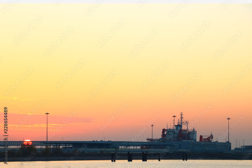 bright sunset with red sun on the background of the port bright sunset with red sun on the background of the port