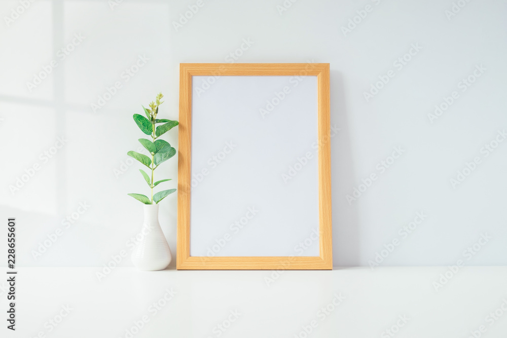 Mock up portrait photo frame with green plant on table, home decoration. Mock up portrait photo frame with green plant on table, home decoration.