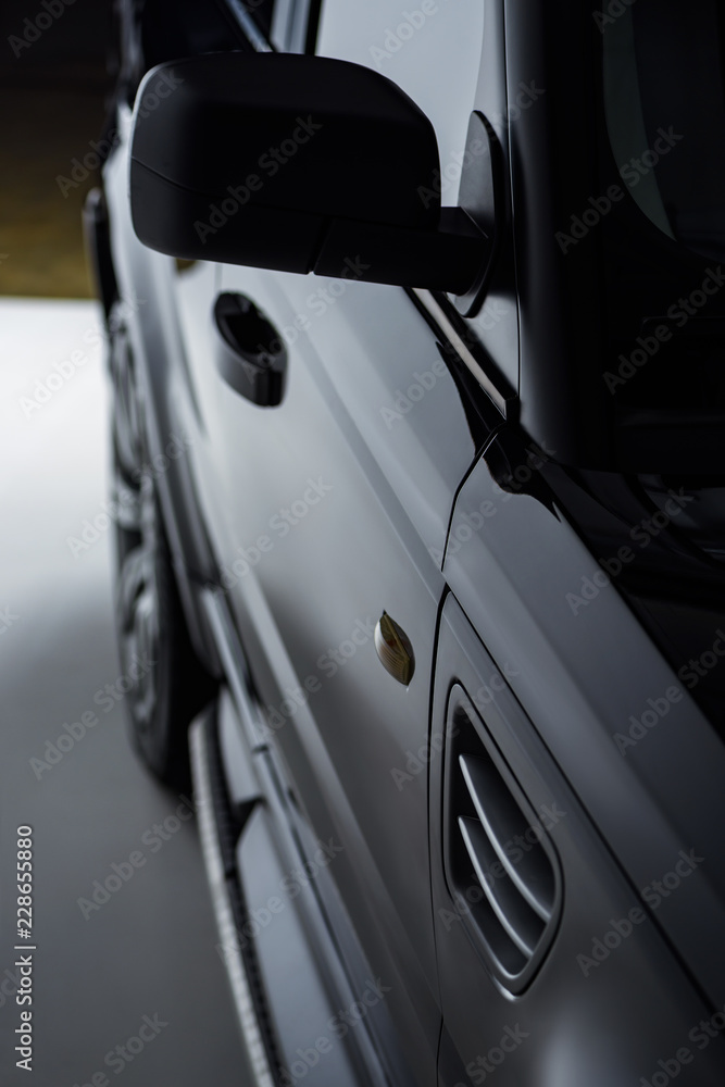 close up view luxury shining black automobile on dark background close up view luxury shining black automobile on dark background