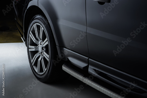 close up view luxury shining black automobile on dark background © LIGHTFIELD STUDIOS