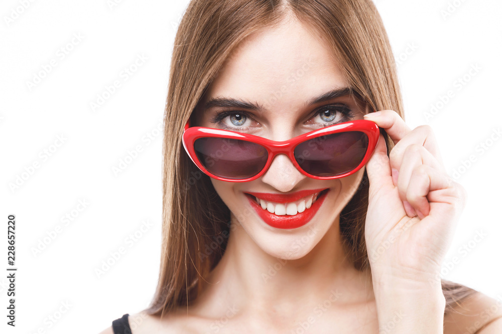 Gorgeous brunette woman wearing black dress and sunglasses smiling and looking out of glasses on the white background, concept of consumerism, sale, rich life Gorgeous brunette woman wearing black dress and sunglasses smiling and looking out of glasses on the white background, concept of consumerism, sale, rich life