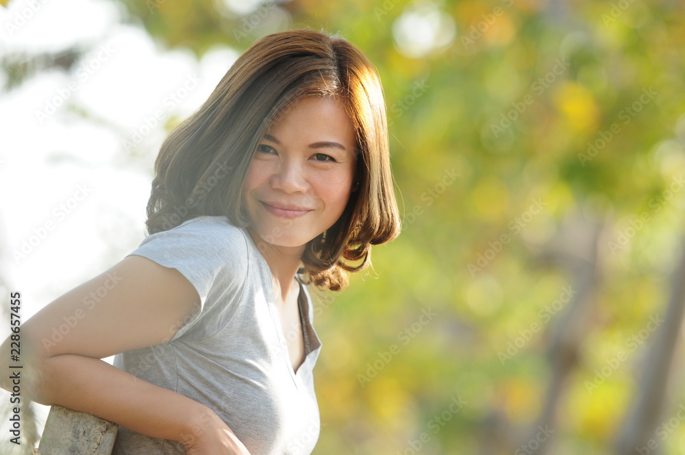 Asian girl smiling and feeling happy in the park in a sunny summer day, Have a beautiful day and happy concept. Asian girl smiling and feeling happy in the park in a sunny summer day, Have a beautiful day and happy concept.