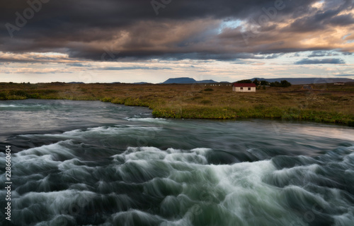 Typical Rural Icelandic house at river Coastline. Horizontal shot at the sunset photo