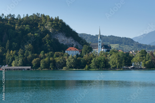 Colorful summer scene in the park of Bled town with medieval castle Blejski grad. Morning in Julian Alpine. Slovenia, Europe. photo